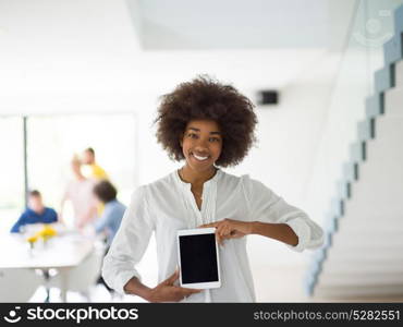 african american Businesswoman using tablet with coworkers in backgorund having meeting