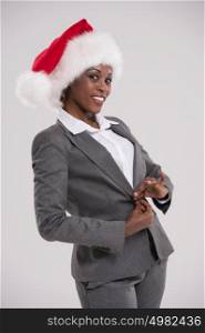 African American businesswoman wearing Santa Claus hat portrait on gray background