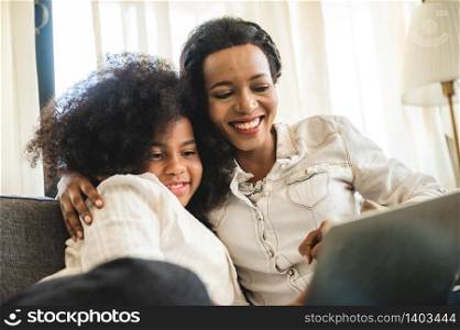 African American children watching on laptop, education at home with mom