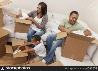 African American family, parents and son, adults and child, unpacking boxes and moving into a new home.