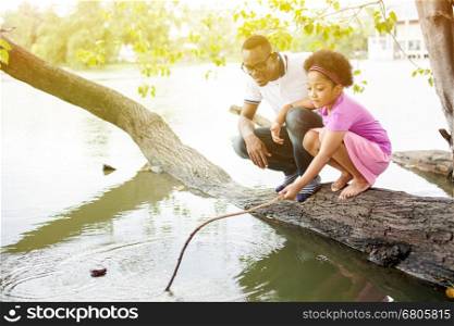 African American family playing around the lake