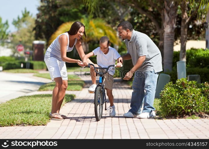 African American Family WIth Boy Riding Bike & Happy Parents