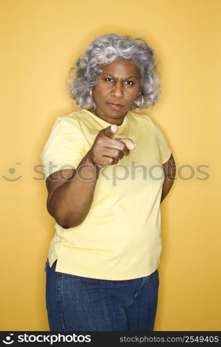 African American female mature adult standing pointing at viewer.