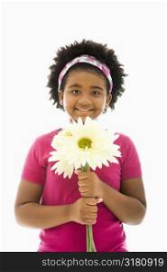 African American girl holding large Gerbera Daisies smiling at viewer.