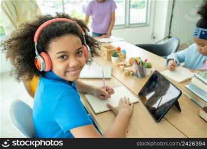 African American girl in headphones watch video lesson on computer at home,Happy children in earphones have online web class using laptop,Distance education.