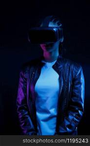 African american girl in vr glasses, watching 360 degree video with virtual reality headset isolated on black background, illuminated by neon lights
