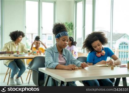 African American girl school children studying together in classroom. Groups of school children working on task,Student children doing test in primary school.