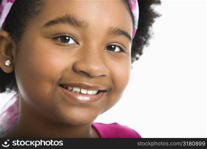 African American girl wearing headband smiling at viewer.