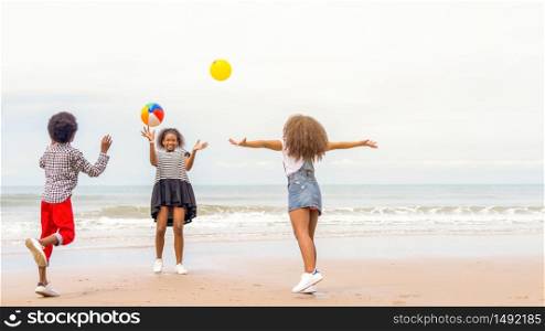 African American, group of children or sister brother play fun throwing balloons at the sea in the summer or on holidays while traveling with family or school.kids play together outside after unlocking down from COVID 19.
