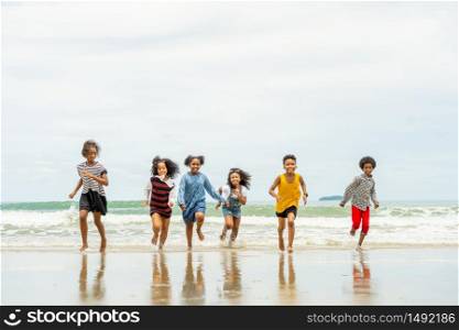 african American,group of children run and play happily together on the beach during summer while vacation with family or school. after unlocking down from COVID 19.