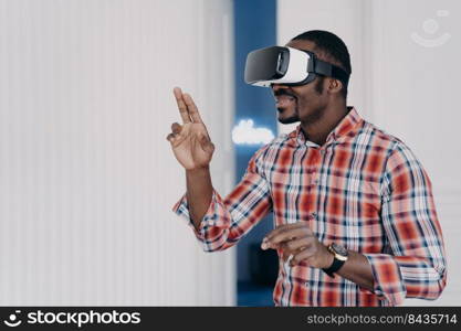 African american guy wearing virtual reality glasses, enjoying leisure free time in cyberspace. Modern black man playing video game simulation, testing purchase in online store. E commerce, tech. African american guy in virtual reality glasses test purchase in online store. Ecommerce, cyberspace