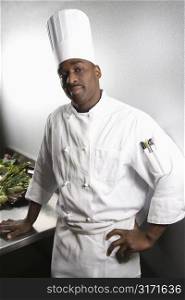 African-American male chef wearing traditional uniform and toque looking at viewer.