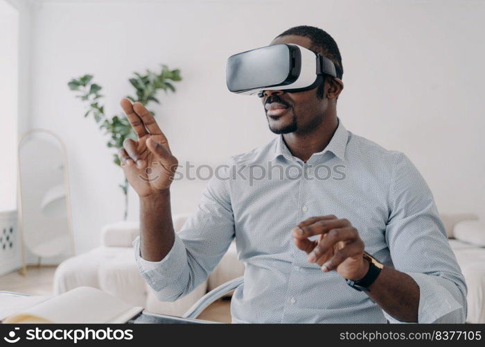 African american male developer or designer wear augmented reality glasses work with 3d objects. Professional employee of high-tech department use virtual reality modeling software. Future high tech. African american man developer in VR glasses use virtual reality modeling software. Future high tech