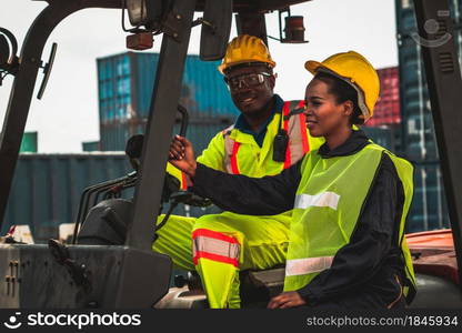 African american man and woman driving forklift in shipyard . Logistics supply chain management and international goods export concept .. African american man and woman driving forklift in shipyard .