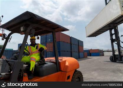 African american man driving forklift in shipyard . Logistics supply chain management and international goods export concept .. African american man driving forklift in shipyard