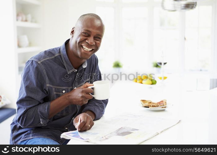 African American Man Eating Breakfast And Reading Newspaper