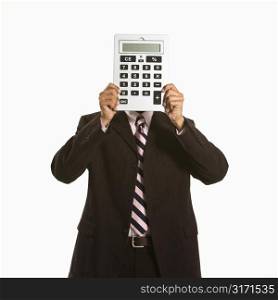 African American man holding oversized calculator over his face.