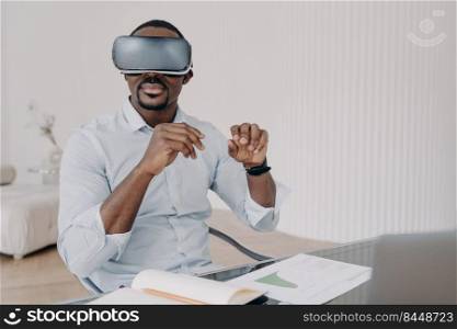 African american man in virtual reality glasses at home. Businessman has online meeting. Freelancer is working on design project. Innovations and digital technology for business and creativity.. African american man in virtual reality glasses at home. Businessman has online meeting.