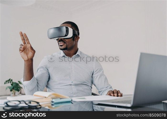 African american man in vr glasses. Businessman has virtual meeting. Freelancer is working on design project on laptop. Modern digital technology and electronic devices for business and creativity.. African american man in vr glasses. Modern digital technology for business and creativity.