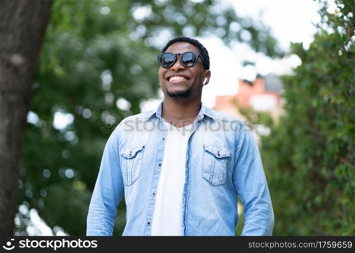 African american man smiling while standing outdoors on the street. Urban concept.