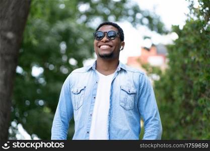 African american man smiling while standing outdoors on the street. Urban concept.