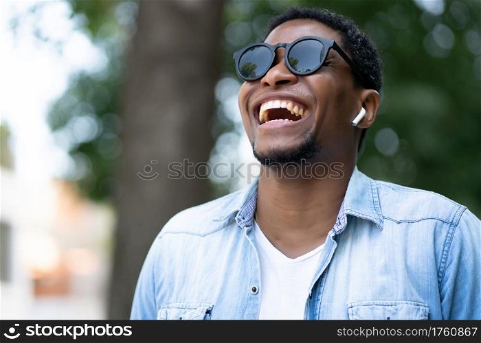 African american man smiling while walking outdoors on the street. Urban concept.