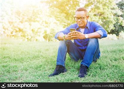 African American man using mobile phone in the park