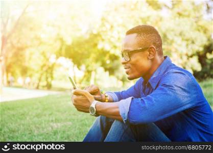 African American man using mobile phone in the park