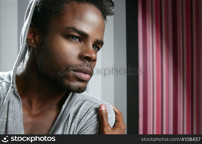African american man with gray hood over wallpaper background