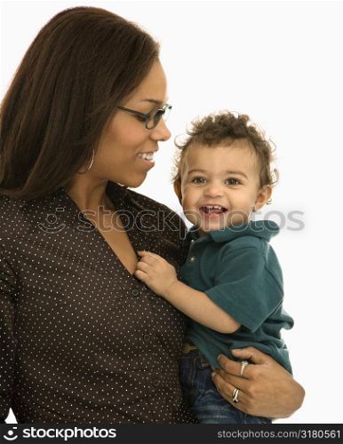 African American mid adult mom holding toddler son with happy expression.