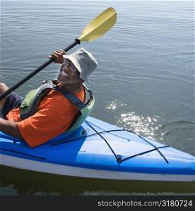 African American middle-aged man smiling at viewer in kayak.