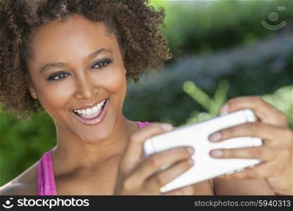 African American mixed race young woman or girl taking selfie photograph using smartphone or cell phone