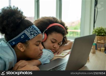 African American school children sleeping on desk at classroom,Girl is tired and sleeps.