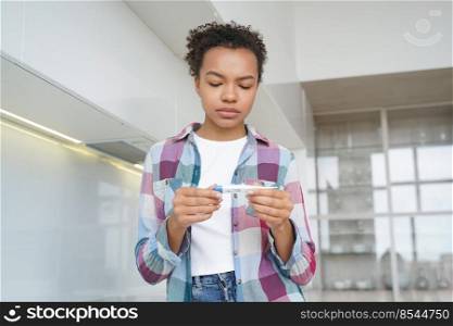 African american teen infected with covid flu measuring check body temperature with digital thermometer. Upset unhealthy young girl measure temp suffer of grip influenza fever, standing at home.. Upset unhealthy african american teen girl check body temperature with digital thermometer at home