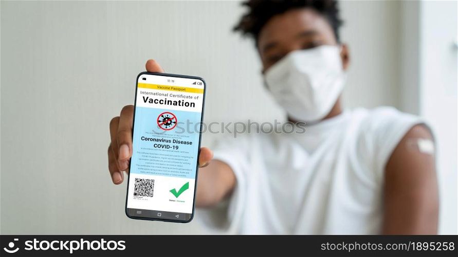 African American teenager shows vaccine passport on mobile phone to validate travel permission by the digital document. African American teenager shows vaccine passport on mobile phone