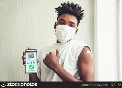 African American teenager shows vaccine passport on mobile phone to validate travel permission by the digital document. Vaccine Passport V5