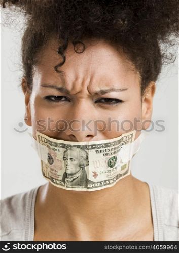 African American woman covering her mouth with a dollar banknote, great concept for the global crises