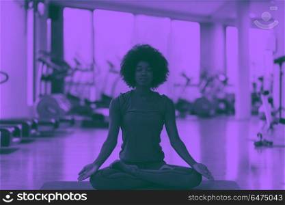 african american woman exercise yoga in gym. beautiful young african american woman exercise yoga in gym duo tone filter