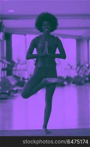 african american woman exercise yoga in gym. beautiful young african american woman exercise yoga in gym duo tone filter