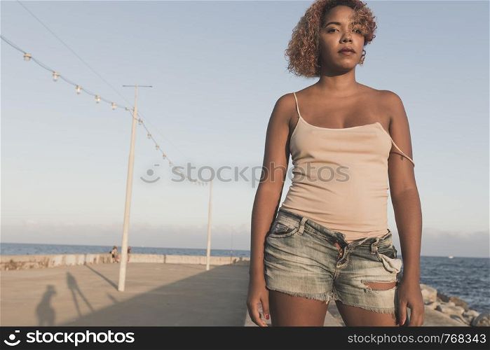 African American woman standup in shorts at Barcelona Beach