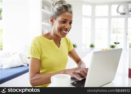 African American Woman Using Laptop In Kitchen At Home