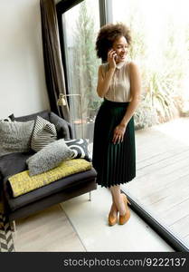 African american woman using mobile phone in the room at home