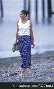 African American Woman Walking Along A Rocky Beach