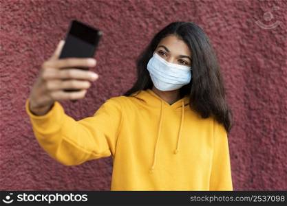 african american woman wearing medical mask taking selfie 2