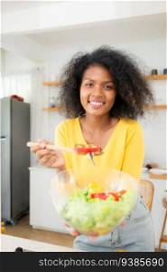 African American woman with bowl of salad in kitchen at home