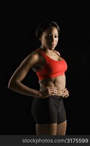 African American young adult woman in athletic apparel with hands on hips.