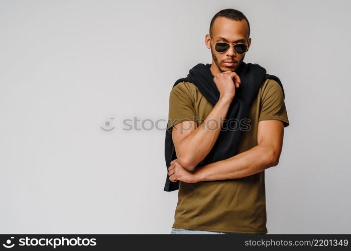african-american young man in green t-shirt over light grey background with copy space.. african-american young man in green t-shirt over light grey background with copy space