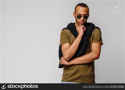 african-american young man in green t-shirt over light grey background with copy space.. african-american young man in green t-shirt over light grey background with copy space