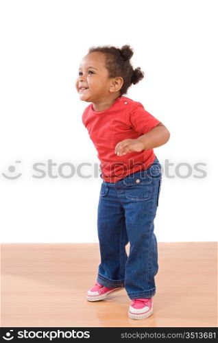 African baby girl on tiptoe on a over wooden floor