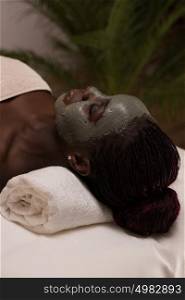 African beauty woman getting mud mask at spa